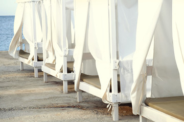 White wooden sunbeds on the beach, close up