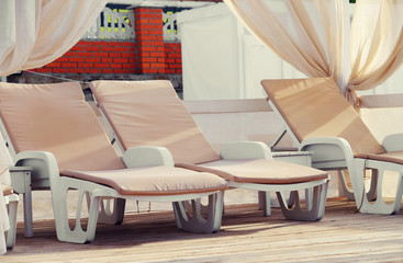 White wooden sunbeds on the beach, close up