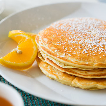 Pancakes with sugar powder on white plate