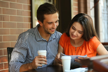 Young couple drink coffee in cafe outdoors