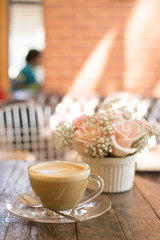 hot coffee and bouquet of flower on grunge wood table