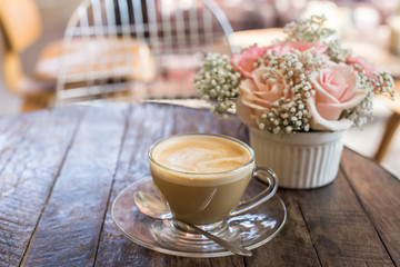 hot coffee and bouquet of flower on grunge wood table