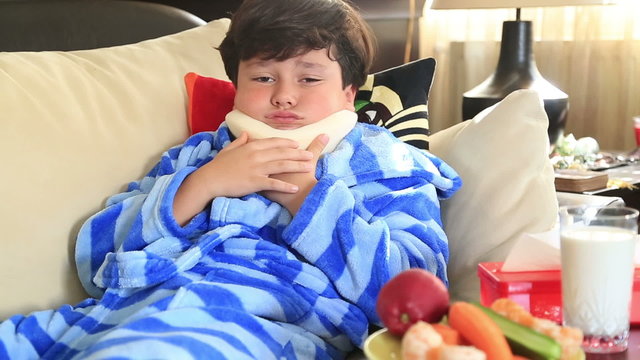 Portrait of a little boy  with a neck brace sitting on a couch