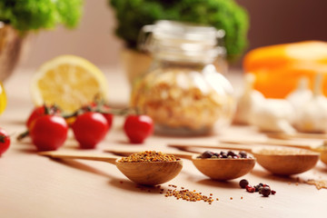 Variety of spices in spoons on the kitchen table