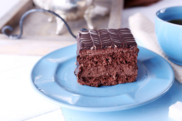 Served table with a cup of tea and chocolate cakes on blue plates close-up