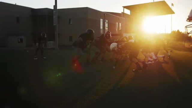 Two Football Players Bump Chests And High Five After A Good Play, With Lens Flare
