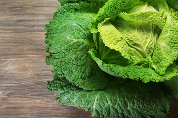 Savoy cabbage on wooden background, close up