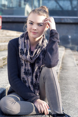 Fototapeta premium Cheerful Cute Teenage Blond Girl Outdoors Sitting On Stairs