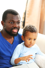 Fototapeta premium Father and son on sofa in the room