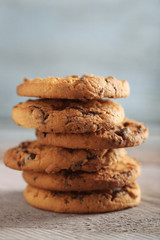 Close up focus view on cookies with chocolate crumbs on wooden table against blurred blue background