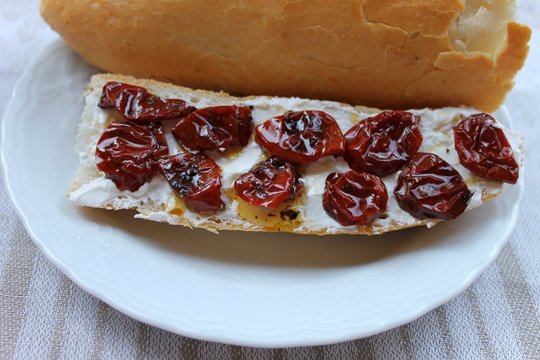 Baguette sandwich with soft cheese and sun-dried tomatoes