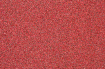 Fototapeta premium Red rough textured sandpaper background, close up