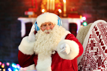 Santa Claus sitting with headphones sitting in comfortable rocking chair at home