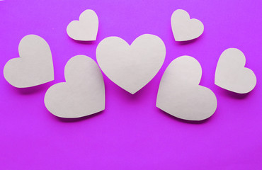 Obraz premium Paper hearts on purple paper background, close-up