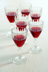 Glasses of red wine on table on bright background