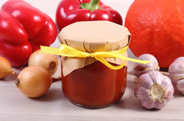 Sauce of pumpkin in glass jar and ingredients on wooden table