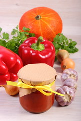 Sauce of pumpkin in glass jar and ingredients on wooden table
