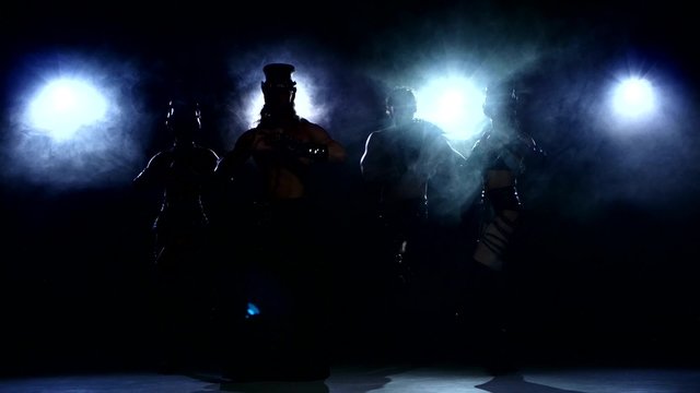 Stripease policeman: four person dancing, on dark
