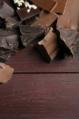 Variety of chocolate pieces on wooden background