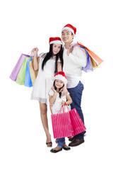 Excited family with shopping bags standing in studio