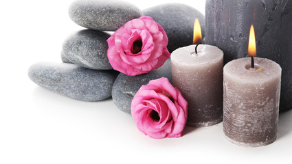Fototapeta na wymiar Aroma candles with pebbles and flower isolated on white background
