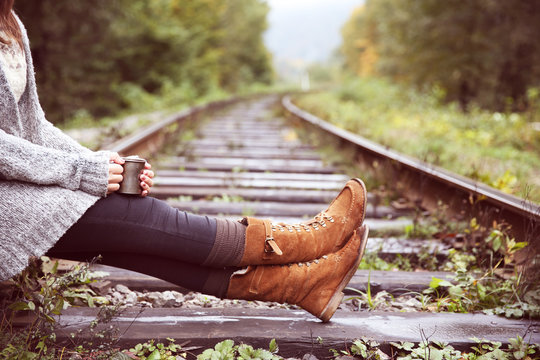 Young woman sitting on rail track