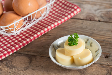 Egg Tofu in white dish on wood table.