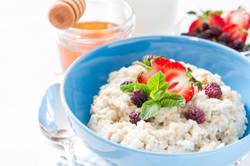 Breakfast - oatmeal with honey and berries, blue bowl
