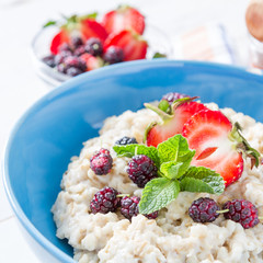 Breakfast - oatmeal with honey and berries, blue bowl