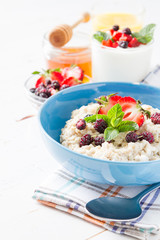 Breakfast - oatmeal with honey and berries, blue bowl