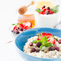 Breakfast - oatmeal with honey and berries, blue bowl