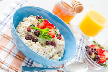 Breakfast - oatmeal with honey and berries, blue bowl