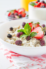 Breakfast - oatmeal with honey and berries, blue bowl