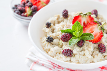 Breakfast - oatmeal with honey and berries, blue bowl