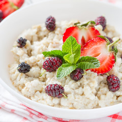 Breakfast - oatmeal with honey and berries, blue bowl