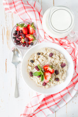 Breakfast - oatmeal with honey and berries, blue bowl