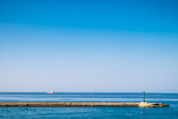 Breakwater with gates to harbor in it at sunrise with cloudless sky