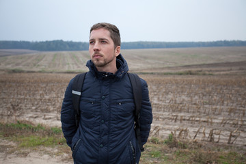 Attractive unshaven man on the background of the autumn landscap