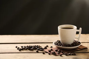 Fotobehang Kopje koffie en koffiebonen op houten tafel, op grijze achtergrond © Africa Studio