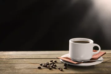 Poster Cup of coffee and coffee grains on wooden table, on gray background © Africa Studio