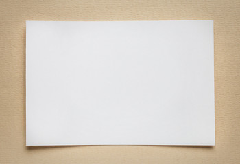 white paper card on beige background, place for text