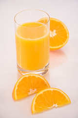 Orangensaft mit halbierter Orange und Orangenvierteln