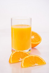 Orangensaft mit halbierter Orange und Orangenvierteln