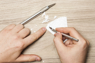 A man carves a snowflake out of paper