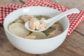 White radish chicken soup in white bowl.