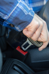 Close Up Of Person In Car Fastening Seat Belt