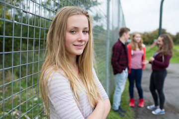 Portrait Of Teenage Girl Hanging Out With Friends In Playground