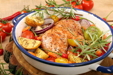 Chicken legs with vegetables and herbs ready for roasting