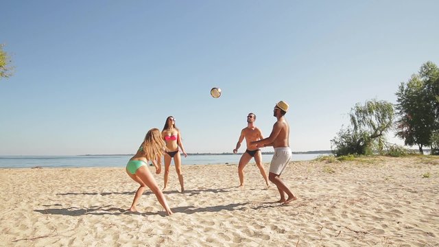 Vacationers playing volleyball on the beach.