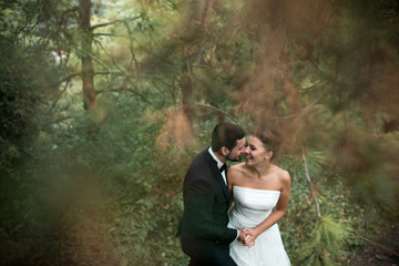 bride and groom dance together in the woods
